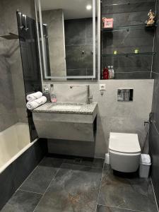 CăuşeniにあるApartament modernの洗面台、トイレ、浴槽を備えたバスルーム