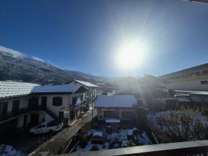 un sole che splende nel cielo sopra alcuni edifici di Appartement 4pers - Hyper centre Bourg St Maurice a Bourg-Saint-Maurice
