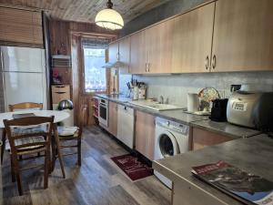 una cucina con lavandino, tavolo e lavastoviglie di Appartement 4pers - Hyper centre Bourg St Maurice a Bourg-Saint-Maurice