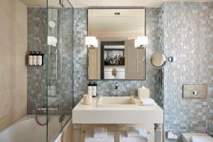 a bathroom with a sink and a mirror and a tub at Sofitel Paris Le Faubourg in Paris