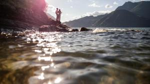 two people standing on a rock in the water at Casa Lago Como in Perledo