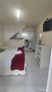 Una gran cocina blanca con una manta roja sobre una cama. en Flats Privé Village Galés, en Maragogi