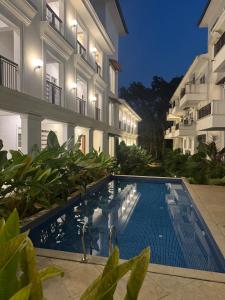 a swimming pool in front of a building at Pansoi - A luxurious cozy stay in Siolim in Oxel