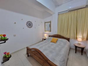 a bedroom with a bed with a yellow pillow on it at Isthmus Filoxenia in Isthmia
