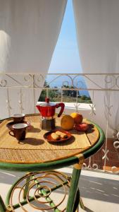 a table with a tea pot and fruit on it at Salina Castel Vinci in Rinella