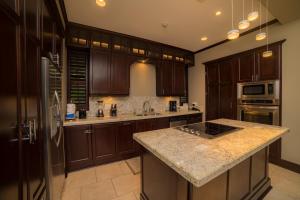 a kitchen with wooden cabinets and a granite counter top at Vista Bahia 3D - 3bdr 3bath plunge pool in La Mona