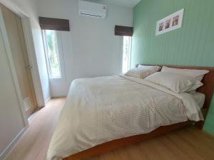 Un dormitorio con una gran cama blanca con paredes verdes. en Cozy Tiny House Nature Retreat with Mountain Views, 