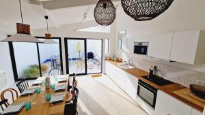een keuken met een tafel en stoelen in een keuken bij Le Corail, maison cosy avec terrasse in Les Sables-dʼOlonne