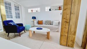een woonkamer met een bank en een tafel bij Le Corail, maison cosy avec terrasse in Les Sables-dʼOlonne