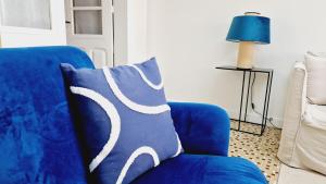 een blauwe bank met een blauw en wit kussen erop bij Le Corail, maison cosy avec terrasse in Les Sables-dʼOlonne