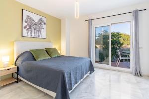 Un dormitorio con una cama y una ventana grande. en 3 bedroom townhouse close to the beach, en Estepona 18 fotos más
