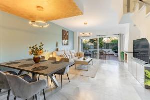 Un comedor y una sala de estar con mesa y sillas. en 3 bedroom townhouse close to the beach, en Estepona
