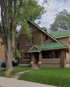 a brick house with a green roof at La Pergola-4 in Quebec City