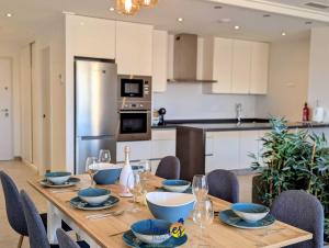 un tavolo da pranzo con sedie e una cucina di Tropical 3BR Oasis with Pool EB17 a Los Dolses