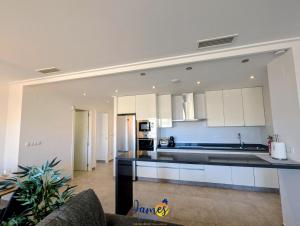 una cucina con mobili bianchi e ripiani neri di Tropical 3BR Oasis with Pool EB17 a Los Dolses