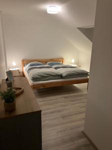 a bedroom with a bed and a desk with a laptop at FEWO-Wölkchen mit Ausblick & Komfort über den Dächern von Weißenfels in Weißenfels