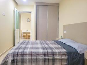 ein Schlafzimmer mit einem Bett und einer karierten Decke in der Unterkunft Castelinho Sal Lodge in Espargos