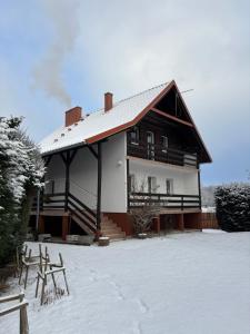 a large house with snow on the ground at Mazurskie Zacisze - sauna, jacuzzi, kominek in Trygort