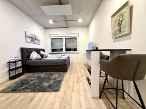 a living room with a couch and a desk at NEU wunderschöne Goldstadt Suite am Schlössle Zentrum Pforzheim in Pforzheim