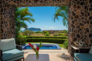 a patio with a view of a pool and palm trees at Vista Bahia 3F 1 bedr 1 1 and a half bath ocean view in La Mona