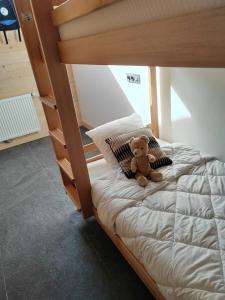 a teddy bear sitting on top of a bed at La Ferme du Praz in Les Contamines-Montjoie