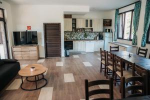 Una sala de estar con mesa y sillas y una cocina. en Къща за гости Бели Осъм, en Beli Osŭm