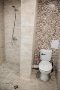 un baño con inodoro y ducha en Къща за гости Бели Осъм, en Beli Osŭm