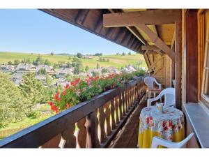 a table and chairs on a balcony with flowers at Kirchlehof in Oberried