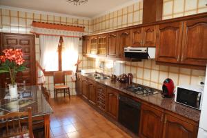 a kitchen with wooden cabinets and a counter top at Casa-Villa en Lorca relax vistas y piscina privada in Lorca