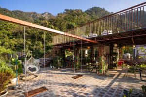 a building with a patio with tables and chairs at LiveAway Rishikesh, Laxman Jhula by PACK in Rishīkesh