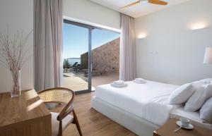 a bedroom with a bed and a sliding glass door at Amber by the sea in Évyiros +67 photos