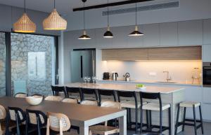 a kitchen with a table and some chairs and a counter at Amber by the sea in Évyiros +67 photos