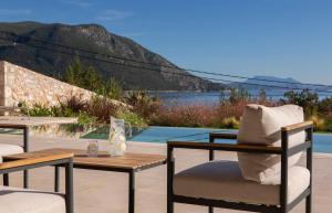 a patio with a table and chairs and a pool at Amber by the sea in Évyiros