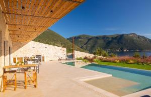 a patio with a table and chairs next to a swimming pool at Amber by the sea in Évyiros