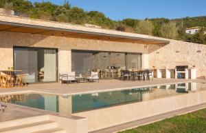a house with a swimming pool and a patio at Amber by the sea in Évyiros