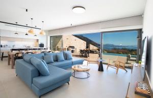 a living room with a blue couch and a table at Amber by the sea in Évyiros