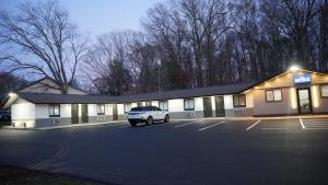 ein Gebäude mit einem auf einem Parkplatz geparkten Auto in der Unterkunft Best Way Inn in Middlefield