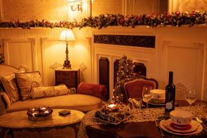 a living room with a couch and a fireplace with christmas decorations at Au Petit Chateau les Bains a Thermen Morvan in Saint-Honoré-les-Bains