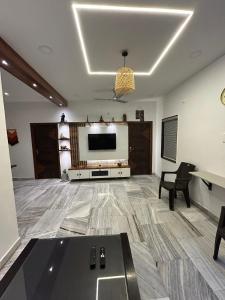 een grote woonkamer met een flatscreen-tv bij Guhan HomeStay- 2BHK Serviced Apartments - Full Furnished & Full Kitchen, WiFi & Balcony in Hyderabad
