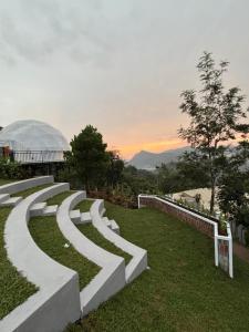 a group of stone steps in a park with a building at Astara Munnar in Anachal +21 photos