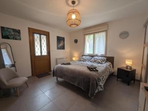 ein Schlafzimmer mit einem Bett, einem Stuhl und einer Lampe in der Unterkunft Le logis du lac in Braucourt