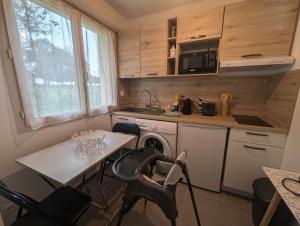 eine kleine Küche mit Tisch und Mikrowelle in der Unterkunft Le logis du lac in Braucourt