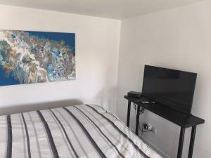 Un dormitorio con una cama y un cuadro en la pared. en L'atelier, chalet proche lac et océan à Hourtin, en Hourtin