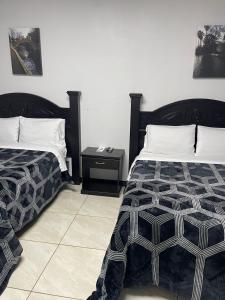 a bedroom with two beds and a side table at Hotel Plaza Berrendo in Campo Menohita 307