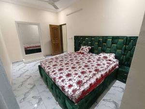 a bedroom with a bed with a green tufted headboard at Premium House Kouritenga ISPP in Ouagadougou