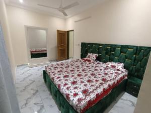 a bedroom with a bed with a green tufted headboard at Premium House Kouritenga ISPP in Ouagadougou