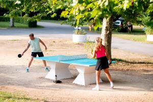 een man en vrouw die een potje tafeltennis spelen bij Camping De Thoissey *** in Thoissey
