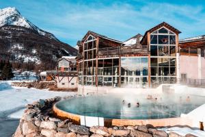 a resort with a hot tub and a mountain at Le montagnard in Le Monêtier-les-Bains