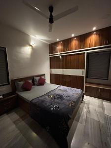 een slaapkamer met een bed en een plafondventilator bij Guhan HomeStay- 2BHK Serviced Apartments - Full Furnished & Full Kitchen, WiFi & Balcony in Hyderabad