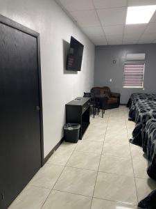 a room with two beds and a desk and a table at Hotel Plaza Berrendo in Campo Menohita 307